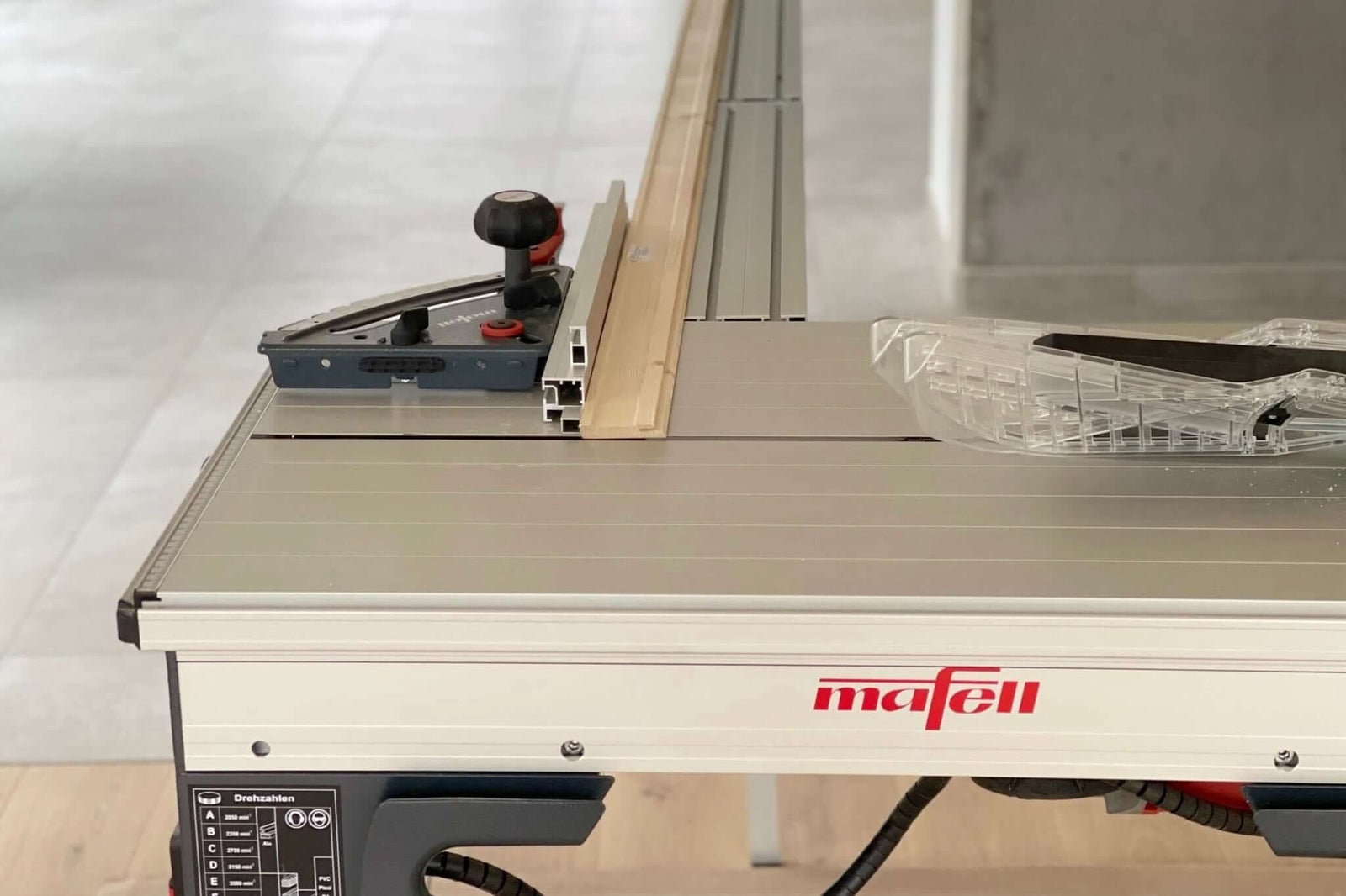 RUWI tafelverlenging op de Mafell Erika, detailfoto van de klembevestiging op de machinetafel naast het Mafell-logo